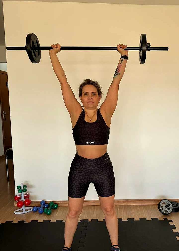 Treino funcional com barra na área de pesos do studio