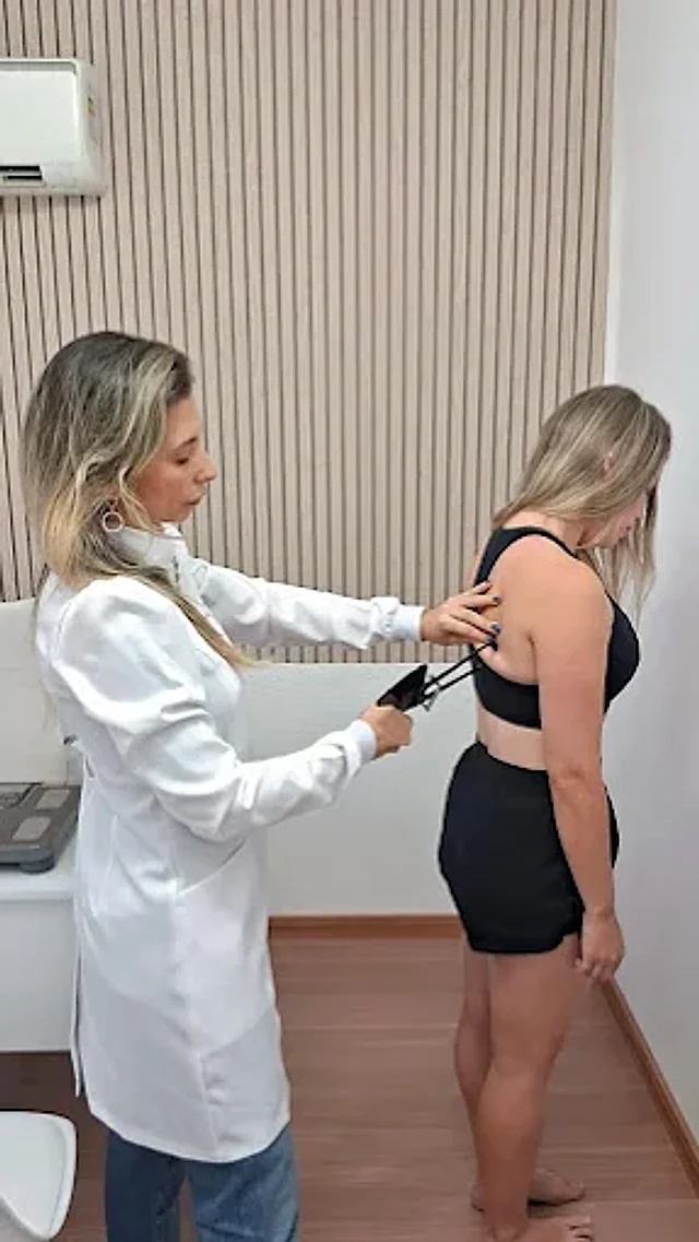 Tatiana Pedroso fazendo avaliação com adipômetro no consultório do studio